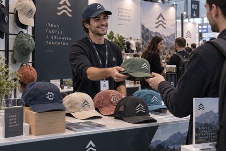 Entrega de gorras personalizadas en un stand de feria